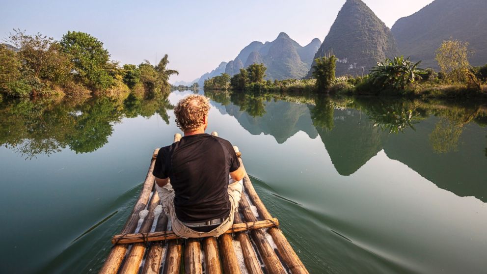Intrepid Travel has just announced a $75k, 364-day, 34-country trip around the world. Pictured: A man travels on a bamboo boat in China in an undated stock photo.
