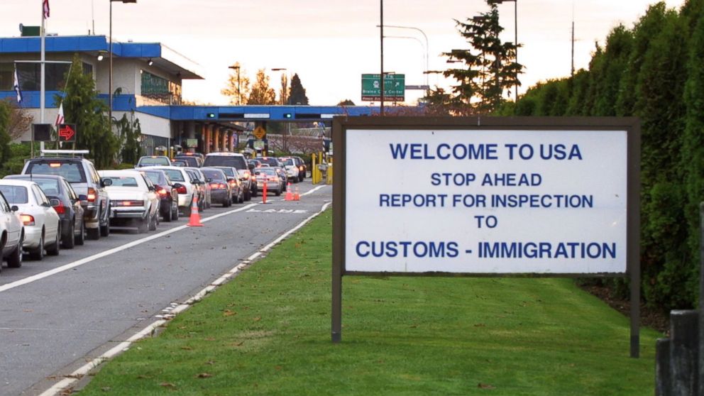 Vehicles line up to enter the United States at the border crossing between Blaine, Washington and White Rock, British Columbia in this Nov. 8, 2001 file photo.