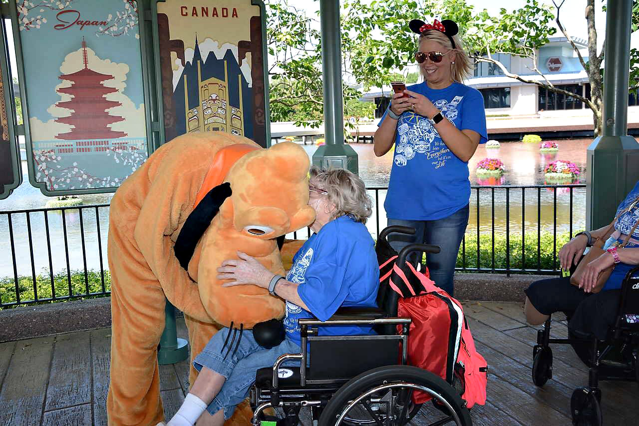 PHOTO: A nursing home resident meets the Disney character, Pluto, while vacationing in Disney's Magic Kingdom in April 2018.