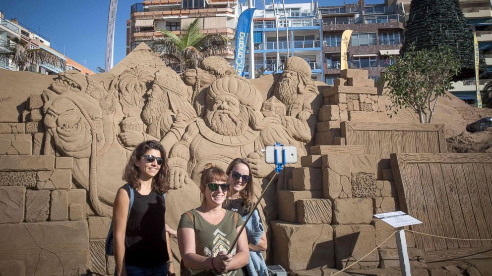 PHOTO: People pose for a selfie in front of sand sculptures depicting Christmas nativity scenes on the international beach resort of Las Canteras in Las Palmas de Gran Canaria on the Spanish Canary island of Gran Canaria on Dec. 7, 2017. 