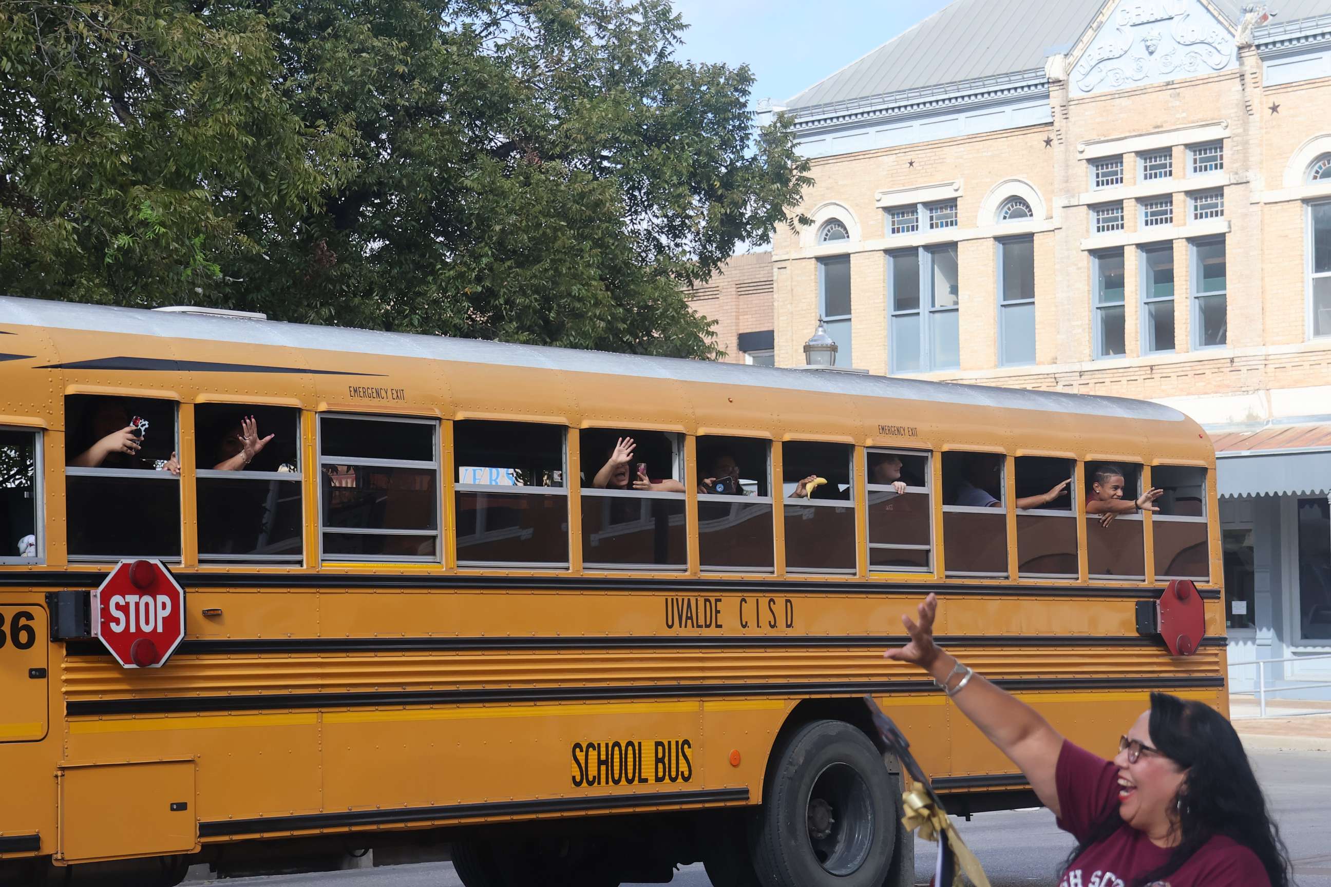 PHOTO: A woman waves at a bus in downtown Uvalde, Texas, on Oct. 14, 2022. Daniel's older brother John was going to a band competition in San Antonio and people gathered to wish the team luck and show their support.