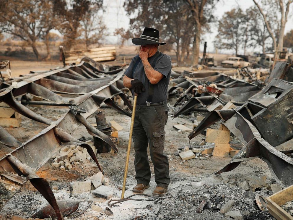 PHOTO: Ed Bledsoe tries to hold back tears as he searches through what remains of his home, Aug. 13, 2018, following the Carr Fire in Redding, Calif.