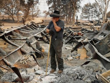 PHOTO: Ed Bledsoe tries to hold back tears as he searches through what remains of his home, Aug. 13, 2018, following the Carr Fire in Redding, Calif.