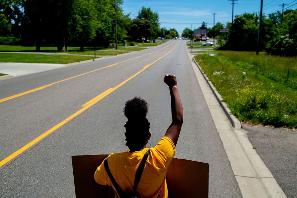 PHOTO: Jernaria Wright, 15, of Beecher, raises her fist as she marches in protest against police brutality and racial injustice, June 13, 2020, in Beecher, Mich.