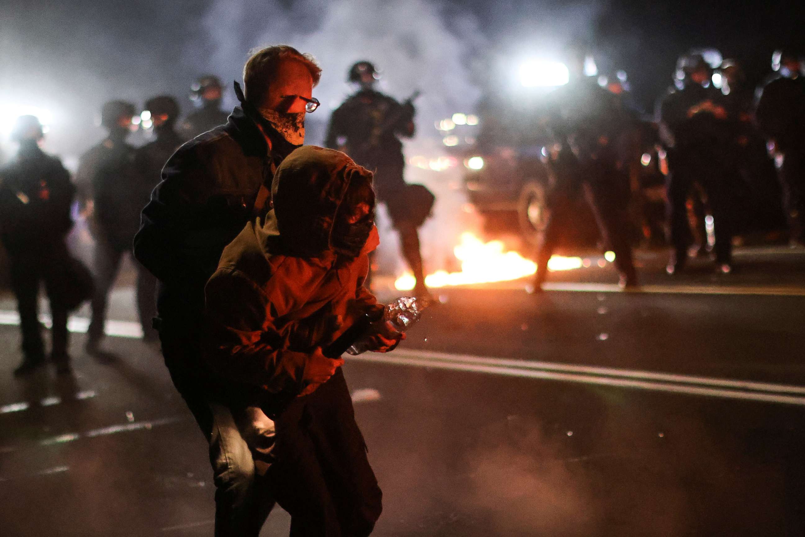PHOTO: A protester is helped by another to retreat after clashing with the police on the 100th consecutive night of protests against police violence and racial inequality, in Portland, Oregon, on September 5, 2020.