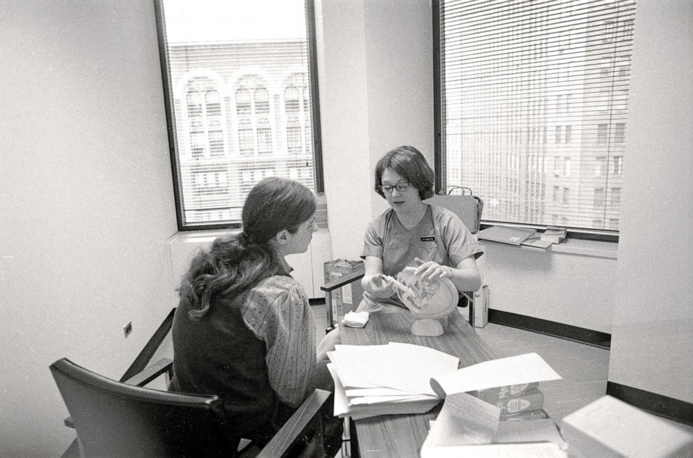PHOTO: A clinic member shows a patient a model of the female reproductive system in the waiting room of the Women's Medical Services abortion clinic  in New  York, on July 7, 1971.