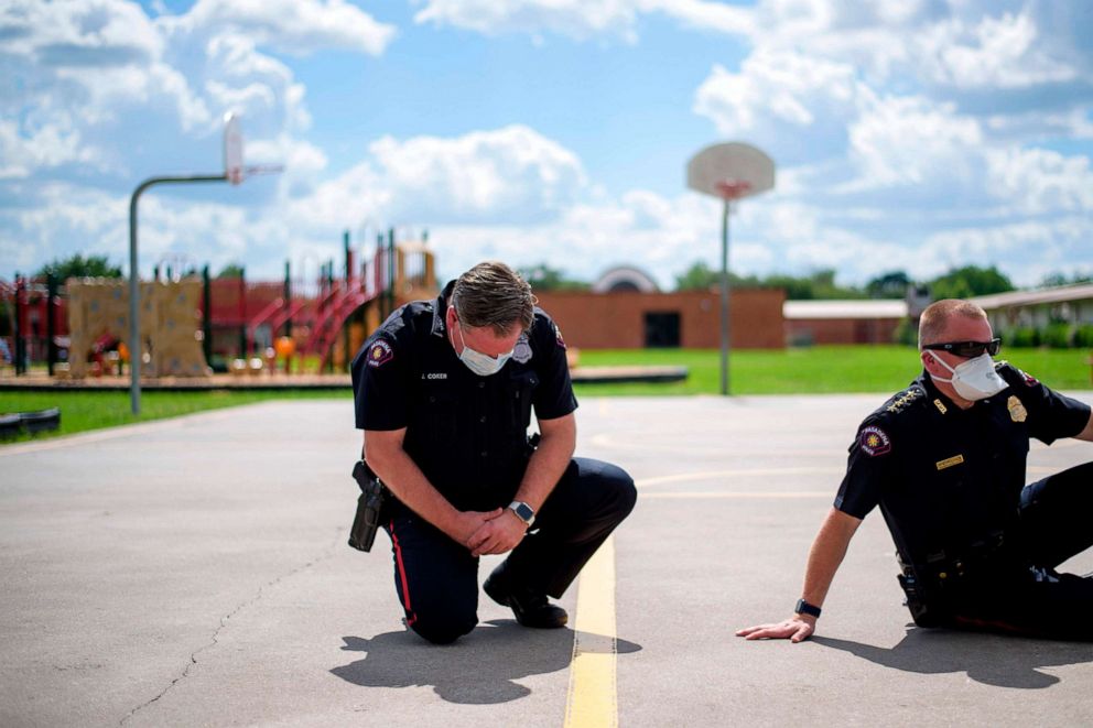 PHOTO: Police officers take a knee and sit along with protestors during a 9 minute moment of silence in honor of George Floyd during a "Sit In Protest" to mourn the death of George Floyd at DeepWater Park in Pasadena, Texas, June 7, 2020.