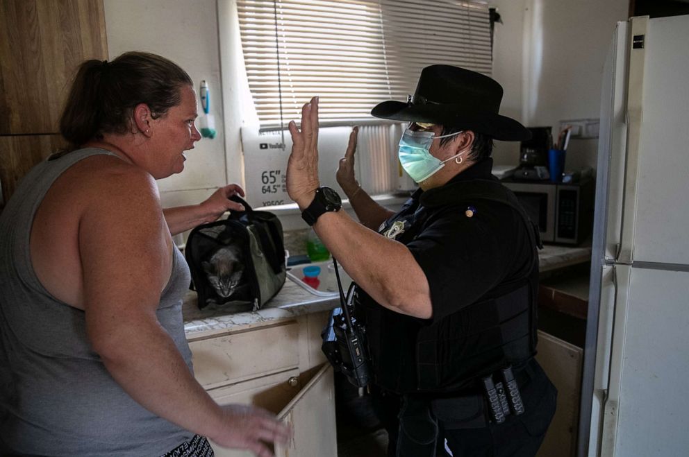 PHOTO: Maricopa County constable Darlene Martinez speaks with a single mother of two after serving her an eviction order for non-payment of rent on Sept. 30, 2020, in Phoenix.