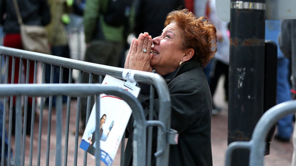 PHOTO: A woman kneels and prays at the scene of the first explosion on Boylston Street near the finish line of the 117th Boston Marathon on April 15, 2013.