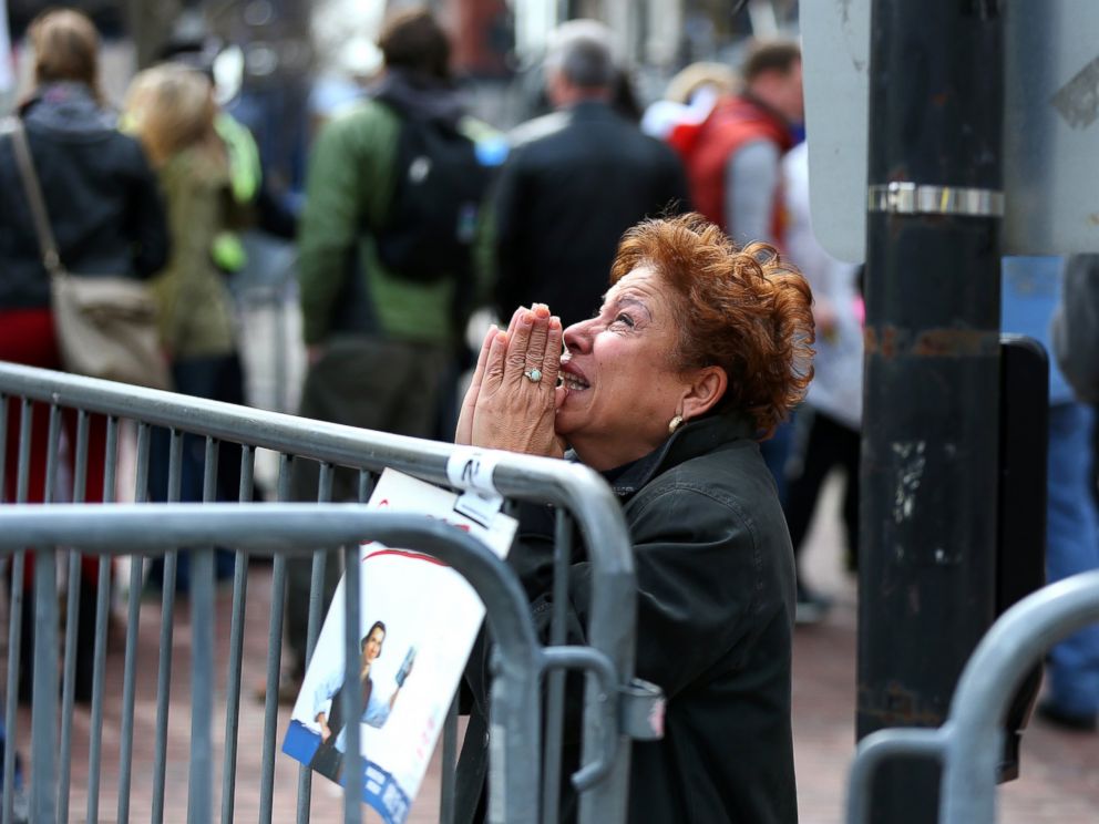 PHOTO: A woman kneels and prays at the scene of the first explosion on Boylston Street near the finish line of the 117th Boston Marathon on April 15, 2013.