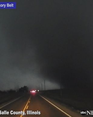 Storm chaser has a close encounter with a massive tornado as it passed over a road in front of him in Illinois.