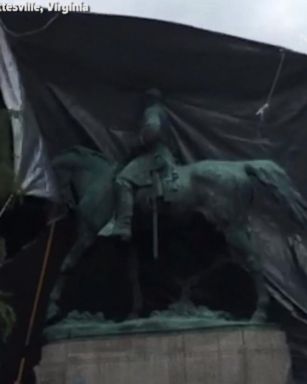 Workers covered two Confederate statues in black in memory of a slain protester.