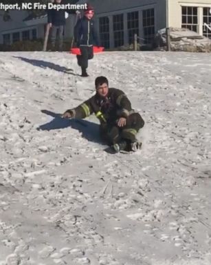 Firefighter joins in on sledding fun