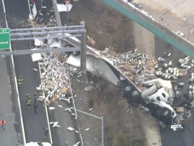 WATCH: Tractor-trailer carrying beer kegs rolls over on interstate