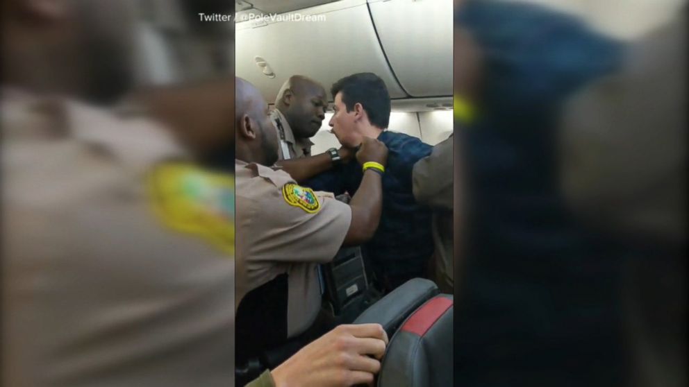 VIDEO: A flight from Miami to Chicago was delayed for over an hour after one passenger was forcibly removed by police following a fight with another passenger.