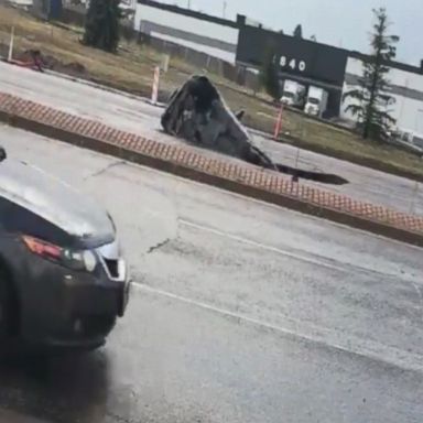 VIDEO: A Colorado woman managed to escape from her vehicle just moments before it fell into a sinkhole in the middle of the street.