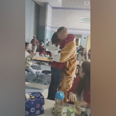 VIDEO: Students are stunned when the school's mascot walking through the cafeteria turned out to be a Coast Guard sergeant surprising his daughter.