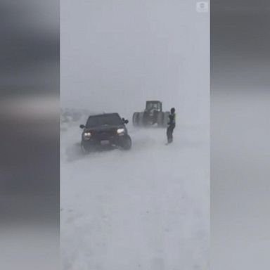 VIDEO: A police vehicle that got stuck in the snow after a massive winter storm blanketed parts of the state received a tow from a farmer, who pulled the car out using their tractor.