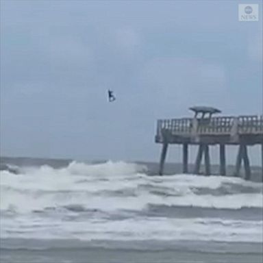 The surfing enthusiast can be seen catching some major airtime past a local pier. 