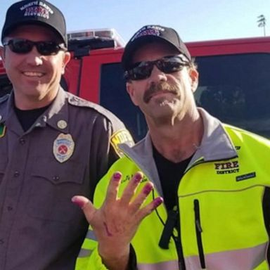 Firemen get their nails painted by little girl