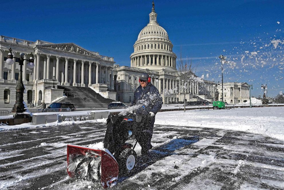PHOTO: Workers remove snow from the East Front of the US Capitol on Jan. 4, 2022 in Washington, D.C., on the day after a heavy snowstorm. 