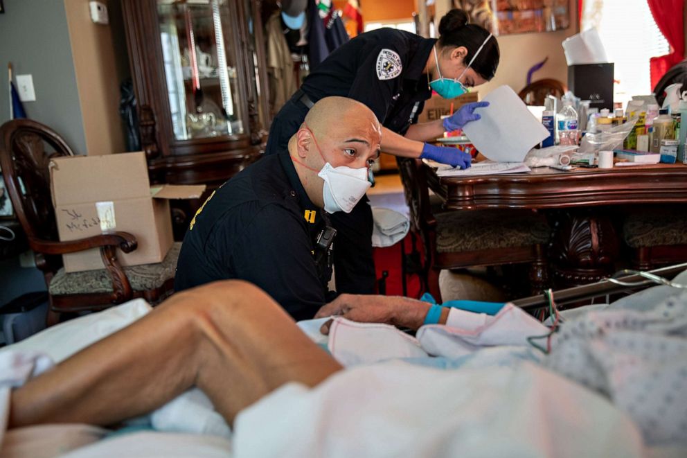 PHOTO: Capt. AJ Briones (paramedic) and Michelle Melo (EMT) prepare to intubate a gravely ill 92-year-old man with COVID-19 symptoms at his home, on April 6, 2020, in Yonkers, New York. 