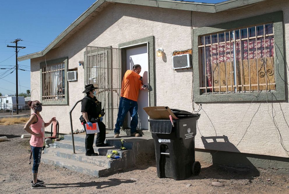 PHOTO: A maintenance man breaks the lock of a house as Maricopa County constable Darlene Martinez serves an eviction order on Oct. 1, 2020, in Phoenix.