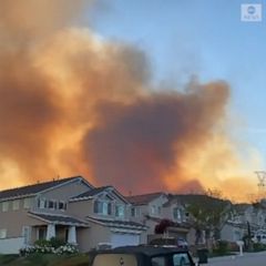 Wildfire smoke rises behind California homes 