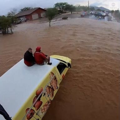 Two men were stranded on the top of a truck in dangerous flash floods that inundated parts of Arizona.