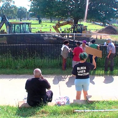 Demonstrators gathered outside an Oklahoma cemetery as the city reburies remains exhumed earlier this summer that could be linked to the 1921 Tulsa Race Massacre.