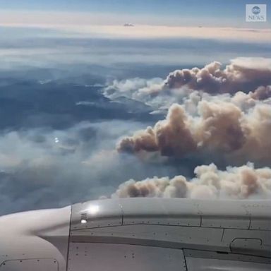 An airplane passenger recorded enormous plumes of smoke from the Dixie Fire that rose 35,000 feet above Northern California. 