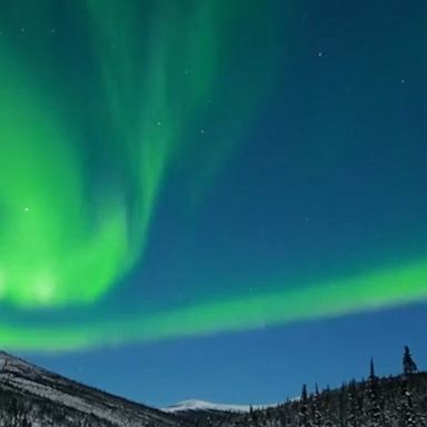 The aurora borealis creates a stunning scene, lighting up the night sky over Alaska's White Mountains.