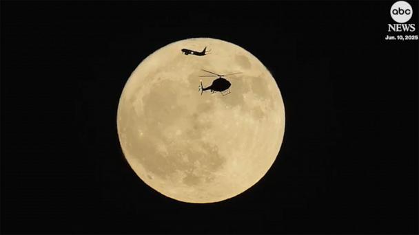 Stunning moment helicopter and plane pass in front of 'strawberry moon' over Chicago