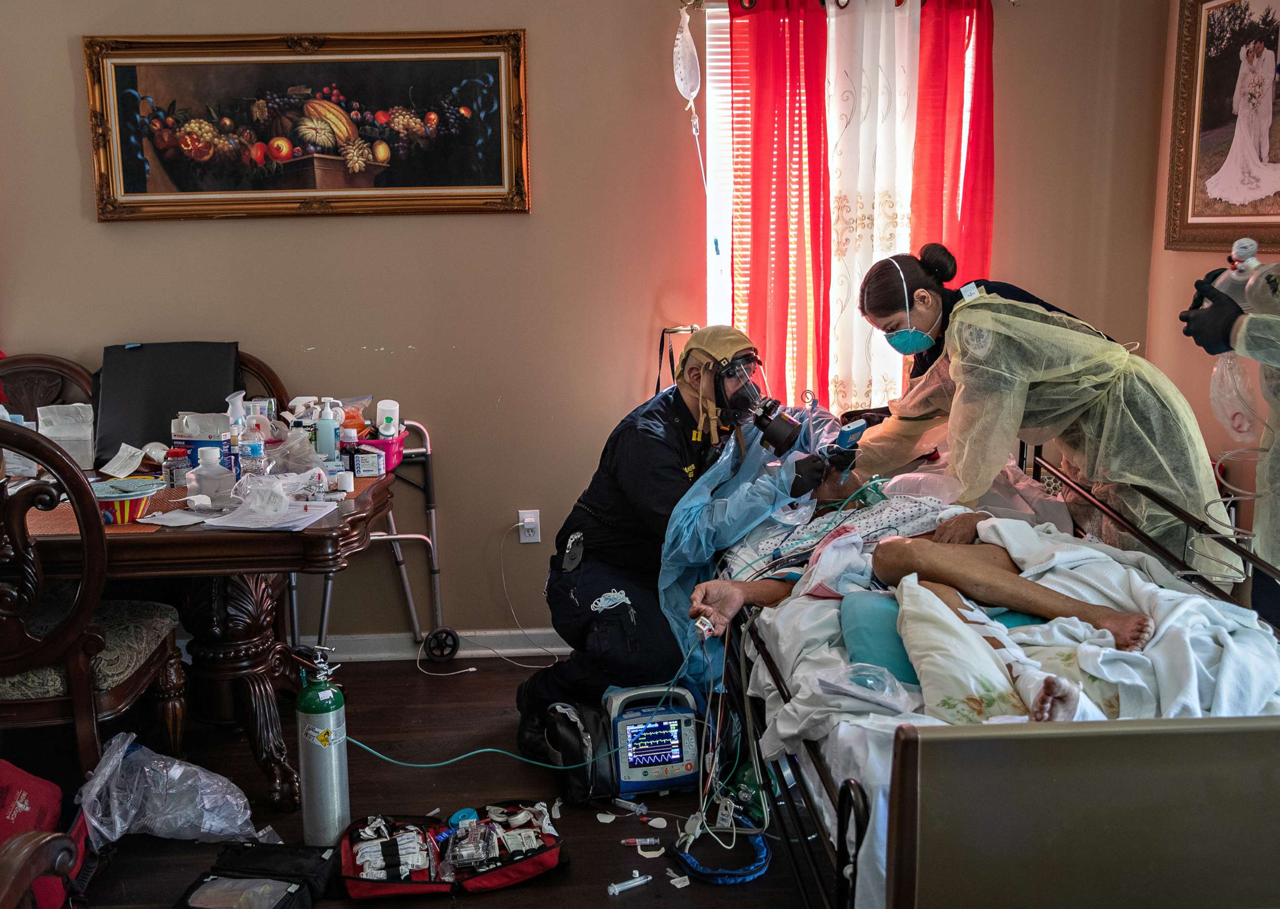 PHOTO: Capt. AJ Briones (paramedic), center, and Michelle Melo (EMT) intubate a gravely ill patient with COVID-19 symptoms at his home, on April 6, 2020, in Yonkers, New York. 