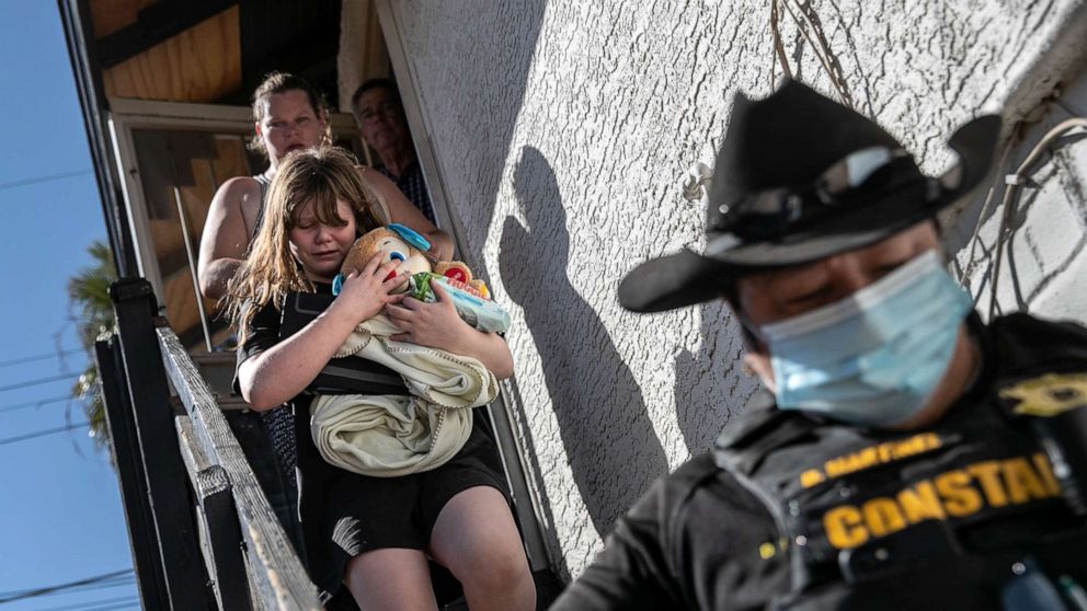 PHOTO: Maricopa County constable Darlene Martinez escorts a family out of their apartment after serving an eviction order for non-payment on Sept. 30, 2020. in Phoenix.