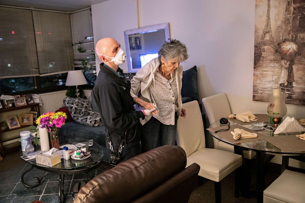 PHOTO: EMT Dan Wellen assists Janet Gazo, 89, who has COVID-19 symptoms, to bring her from her apartment to Stamford Hospital, on April 3, 2020, in Stamford, Conn.