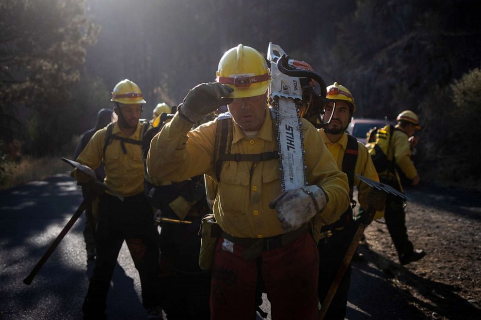 PHOTO: Rhett Howerton, 49, an inmate from Warner Creek Correctional Facility, working as a sawyer, stands with other inmates, working as firefighters, as they prepare to help mop up hotspots from the Brattain Fire near Paisley, Ore., Sept. 20, 2020.
