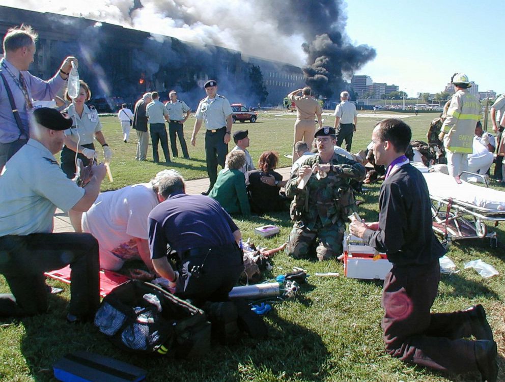 PHOTO: A priest prays over a wounded man outside the west entrance of the Pentagon as emergency workers help the wounded after a terrorist attack, Sept. 11, 2001, in Arlington, Va.