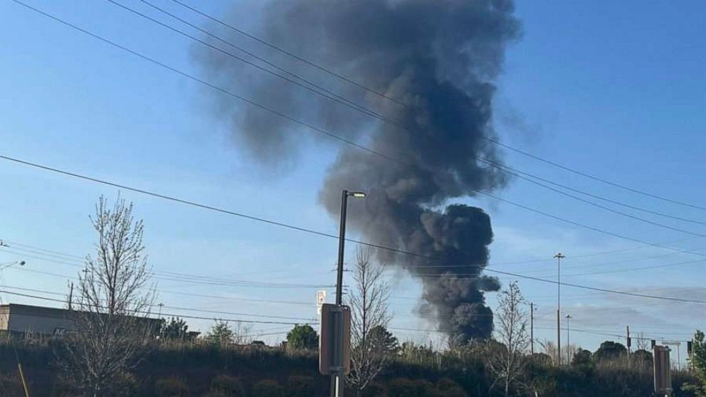 PHOTO: Smoke is seen after a small plane crashed in the lot of a General Mills plant in Covington, Georgia, on April 21, 2022.