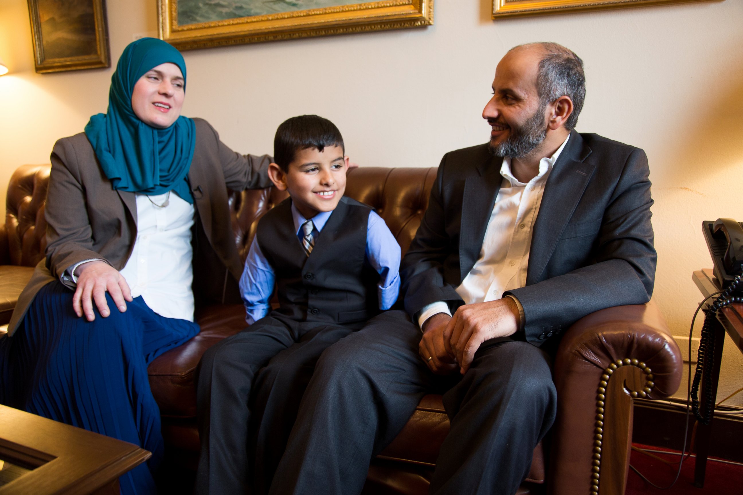 PHOTO: Ahmad Alkhalaf, 9, sits with his father and Nadia Alawa, executive director at NuDay Syria, left. 