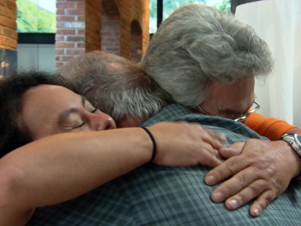 Allen Thomas and his twin children share an emotional hug together.