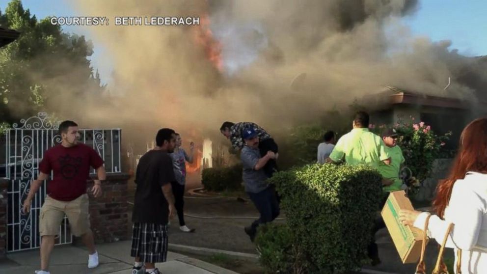 PHOTO: This cellphone video of a house on fire in Fresno, Calif., shows an unidentified man calmly walking toward the house and entering through the flames. Moments later he walks out with a man over his shoulder.