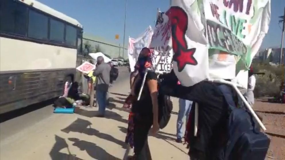 A group of immigrant rights activists block a bus filled with detainees headed to federal court in Tucson, Ariz., Oct. 11, 2013.