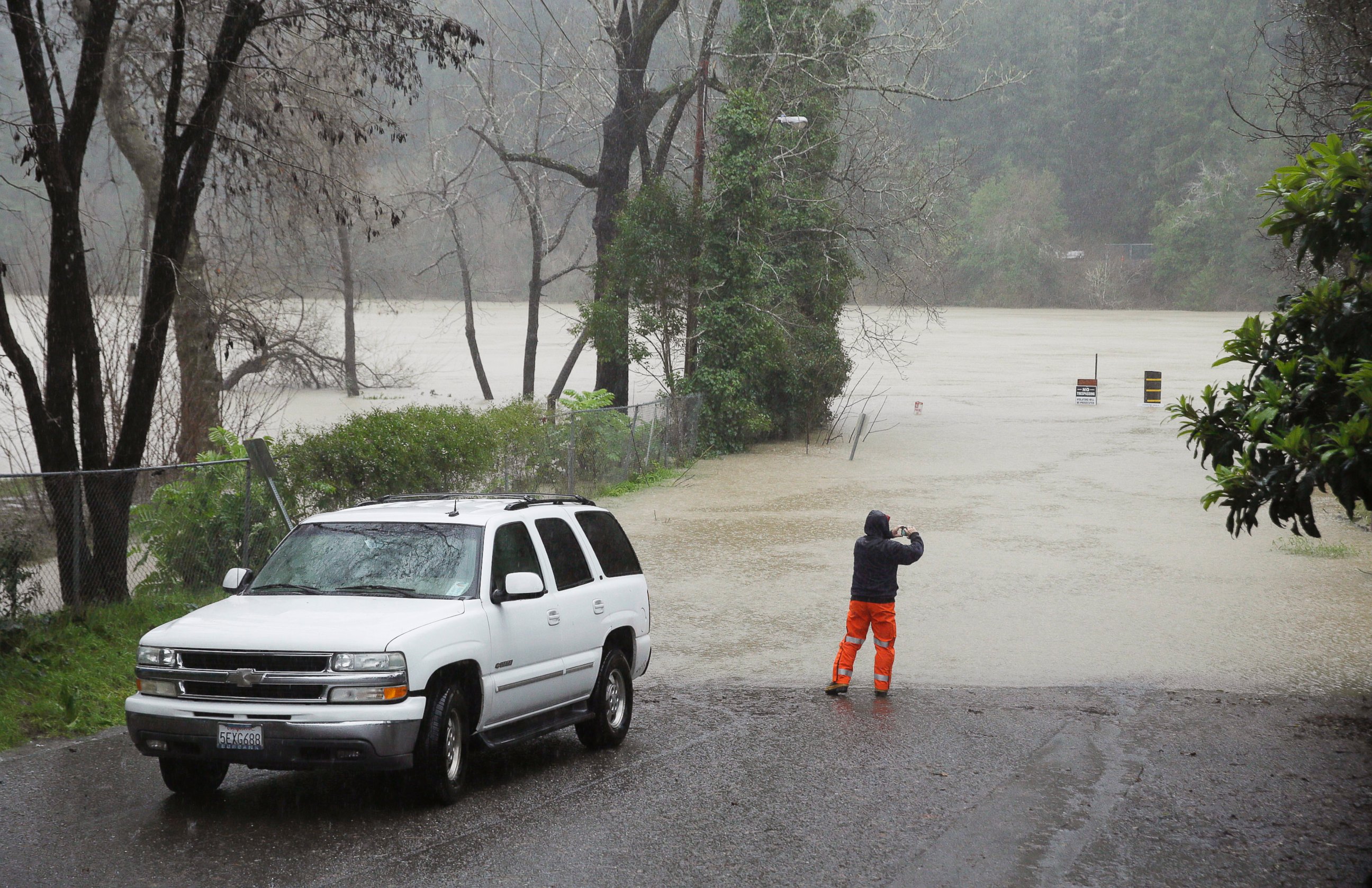 PHOTO: A man stops to take a picture of the Russian River as it floods Johnson's Beach, Jan. 10, 2017, in Guerneville, California. 