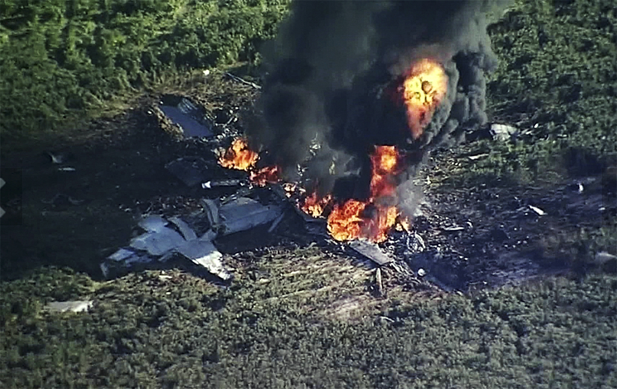 PHOTO: Smoke and flames rise from a military plane that crashed in a farm field, in Itta Bena, Miss., killing several.