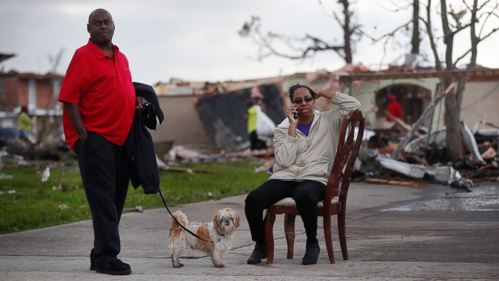 PHOTO: Claire White sits in a chair and talks on the phone next to her husband Roy White and dog "JD" across the street from their destroyed home after a tornado tore through the eastern neighborhood in New Orleans, Feb. 7, 2017. 