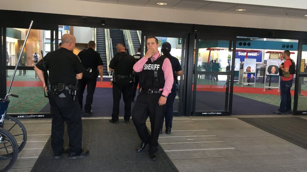 Police officers gather at a terminal at Bishop International Airport, June 21, 2017, in Flint, Mich. Officials evacuated the airport, where a witness said he saw an officer bleeding from his neck and a knife nearby on the ground. On Twitter, Michigan State Police say the officer is in critical condition and the FBI was leading the investigation.