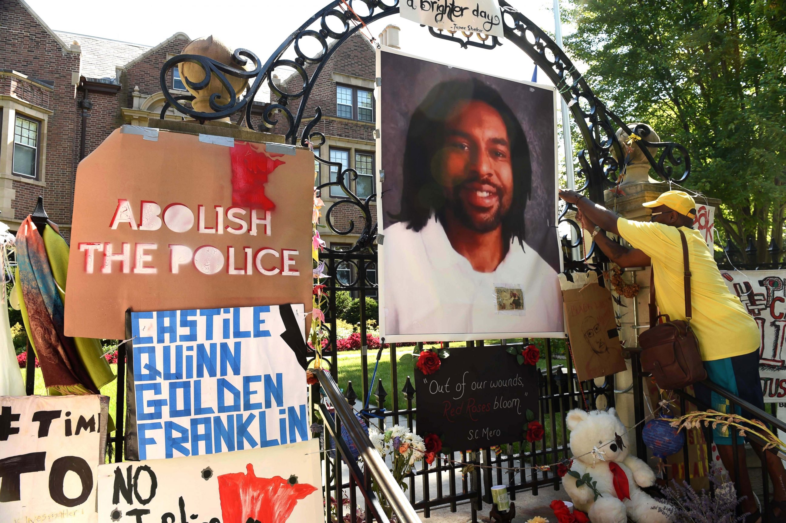 PHOTO: King Demetrius Pendleton hangs a sign on the gate of the Governor's Residence in St. Paul, Minn., as protesters demonstrate against the July 6 shooting death of Philando Castile in Falcon Heights, Michigan, July 24, 2016 .