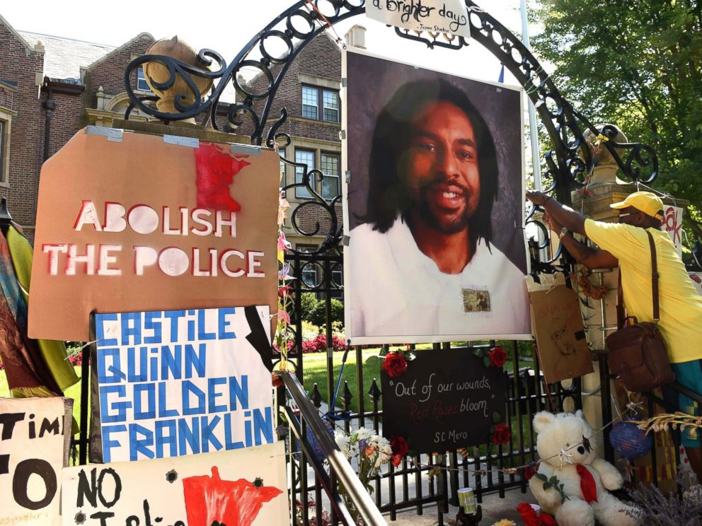 PHOTO: King Demetrius Pendleton hangs a sign on the gate of the Governors Residence in St. Paul, Minn., as protesters demonstrate against the July 6 shooting death of Philando Castile in Falcon Heights, Michigan, July 24, 2016 .