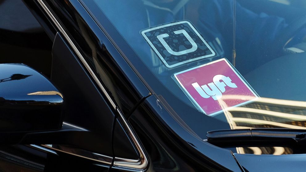 PHOTO: A driver displaying Lyft and Uber stickers on his front windshield, drops off a customer in downtown Los Angeles, Jan. 12, 2016. 